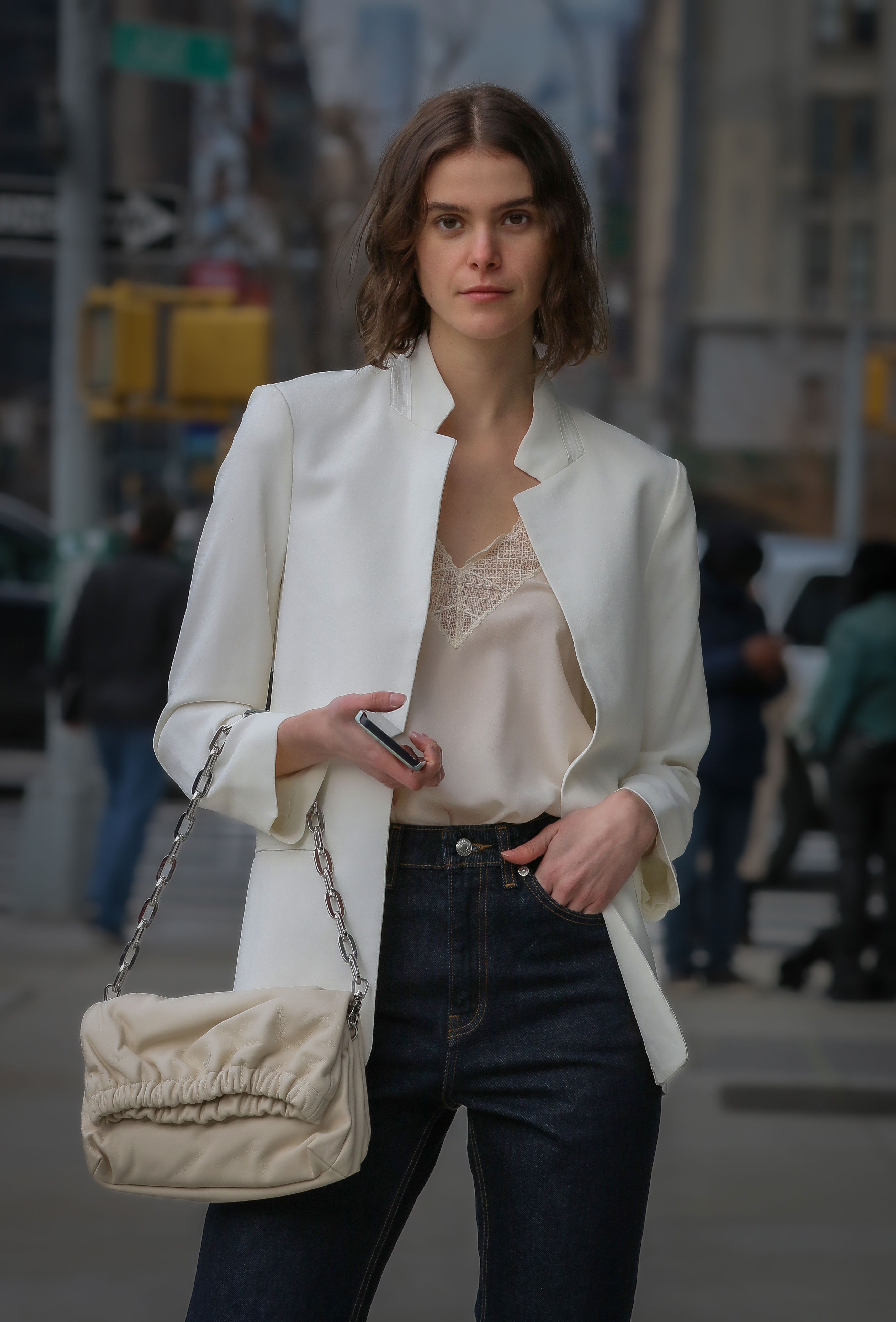 Woman in a modern white blazer and denim on a New York City street